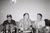 Harry Griffin, Brennan, Joe and Bingo, Manchester, July 2022. Courtesy of the artist. Joe Lycett and friends backstage. On the table in front of them, there are lots of drinks.