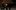 Simone-Tavoni-Resized-aspect-ratio-16-9 A person dressed in a cark suit with short dark hair. They are sitting at a black piano with their hands on the keys.