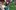 Eco-Fest-aspect-ratio-16-9 A boy in a black baseball camp stands besides a homemade green robot