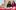 A-Festive-Treat-1-aspect-ratio-16-9 Two young females with dark long hair and glasses sit behind a table. On the table are handmade bead bracelets, knitted christmas toys and other crafter objects. The girls are smiling.