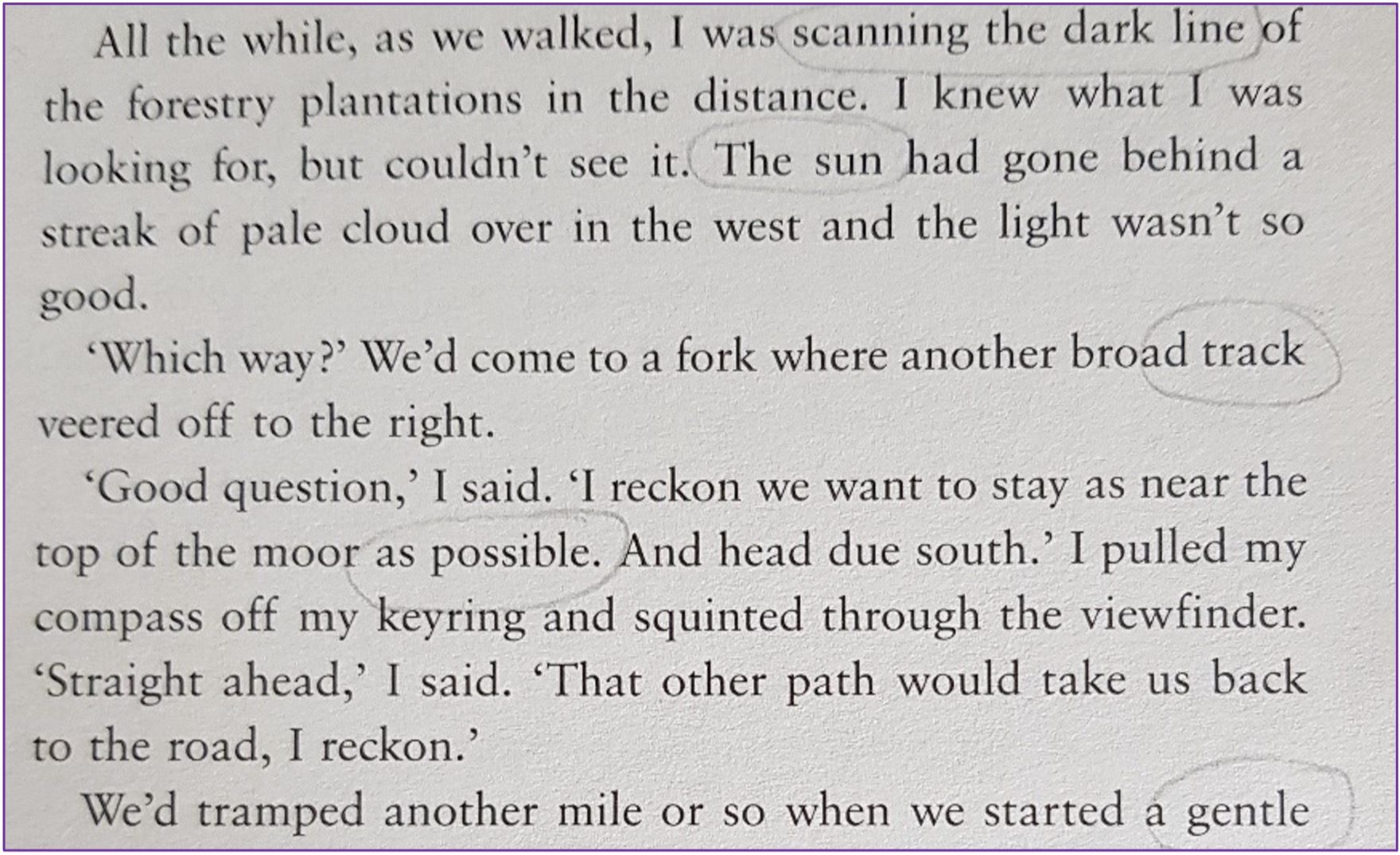 A close-up of a book page with printed text in black on a light background. Several words and phrases are circled in pencil including: 