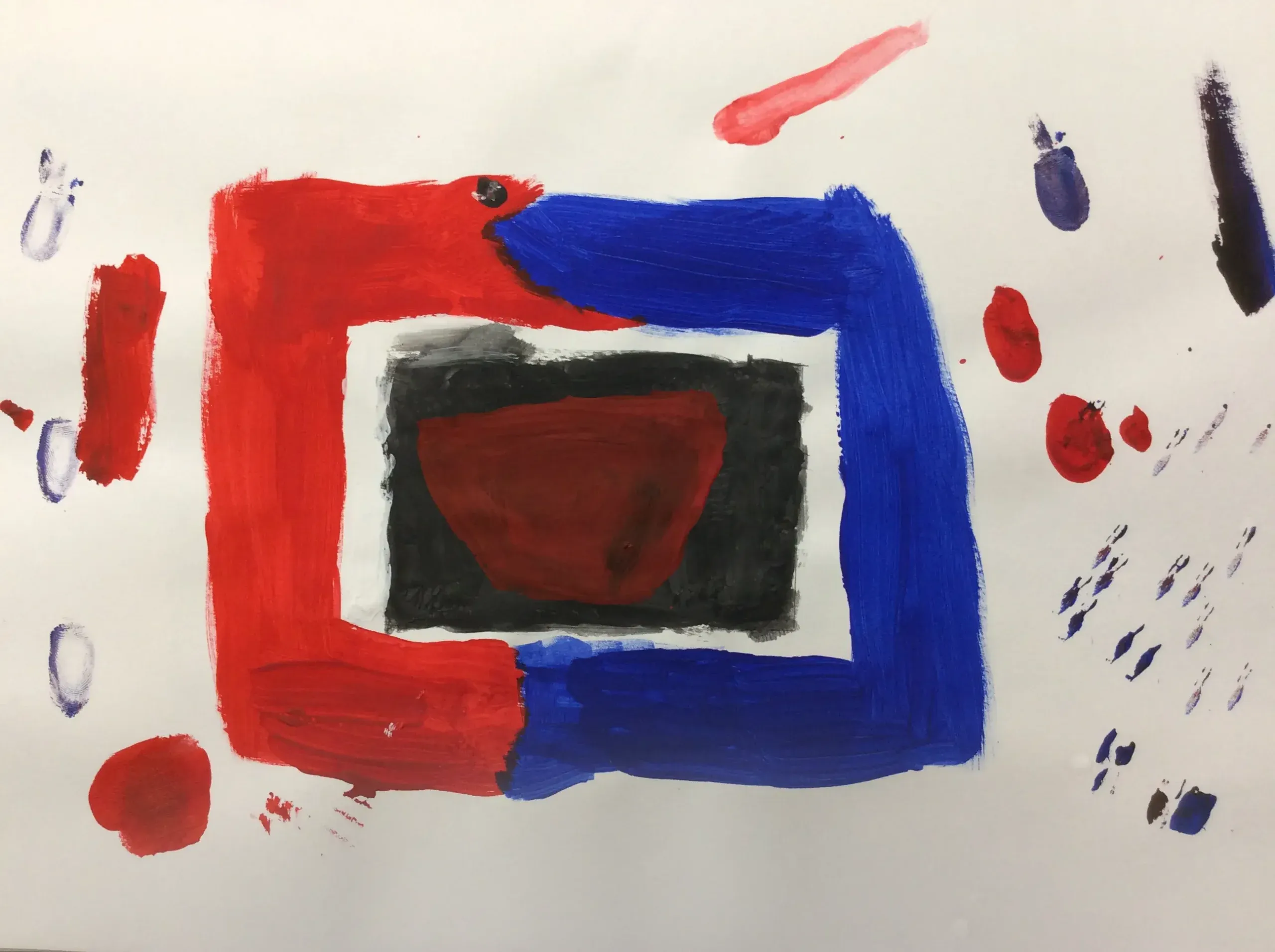 A painting shows a large rectangle outline made of thick red and blue paint on a white background. Inside, there is a smaller black rectangle with a red bowl shape in the middle. Small spots of red, blue, and purple paint are scattered around the outside of the shapes.