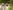 Two girls stand in the long grass with binoculars