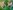 Two foil aluminium star decorations on a green background.